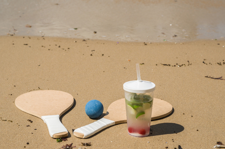 Beach tennis rackets in sand, caipirinha drinkの写真素材