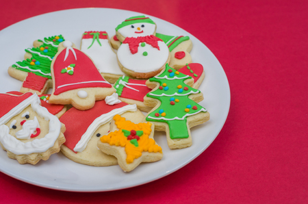 Great christmas background, christmas biscuits on white plate with red backgroundの写真素材