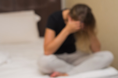 Great background blur with concept of depression, sad woman in bed.の写真素材