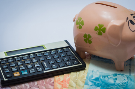 Great concept of economy, financial calculator, piggy bank and Brazilian real money notes.の写真素材
