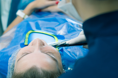 Great concept of dental procedure, young blond Brazilian woman in dental chair suffering dental procedure by dentist.の写真素材