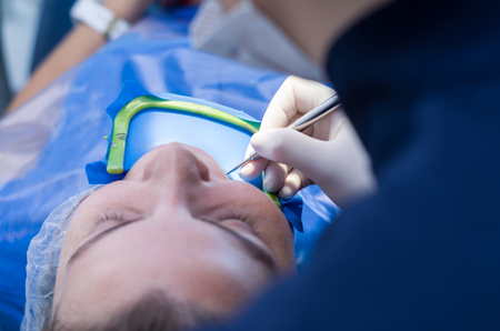 Great concept of dental procedure, young blond Brazilian woman in dental chair suffering dental...