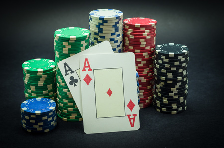 Pair of ace winner, poker chips stacked and pair of aces, black background.