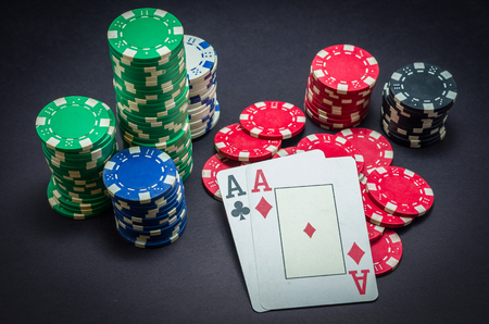 Pair of ace winner, poker chips stacked and pair of aces, black background.の写真素材