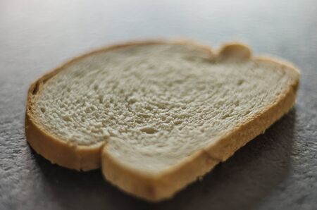 Slice of bread on top of black granite top