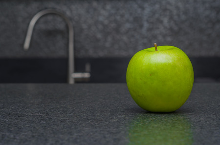 Green apple on black stoneの写真素材