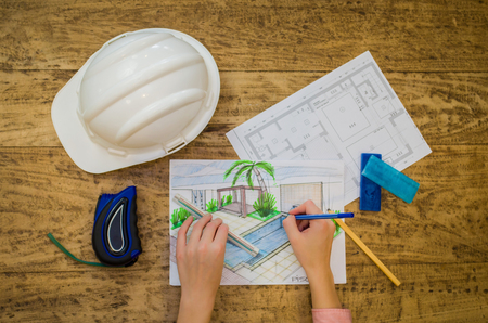 Engineer working, hand of working designer, floor plan, hard hat and sundry objects.の写真素材