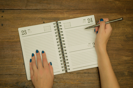 Woman writing hand on scheduleの写真素材