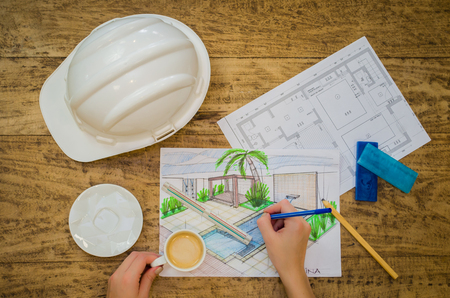Engineer working, hand of working designer, floor plan, hard hat and sundry objects.の写真素材