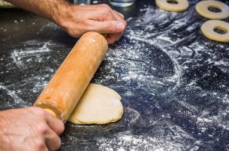 Preparing donuts with roll of pasta in stone.