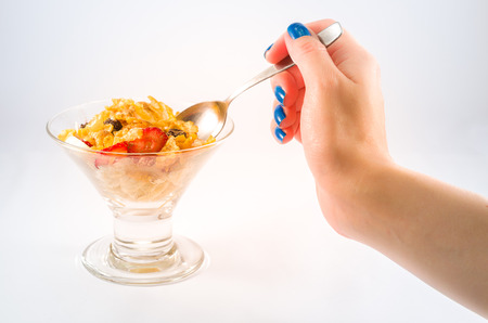 Hand of woman picking up granola with spoonの写真素材