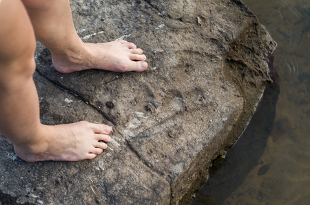 Concept of walking, adventure, legs of woman, stepping on stone.の写真素材