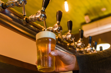 Beer taps on bar counter, brewpub. Craft beer.の写真素材