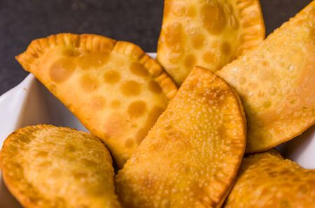 Great photo of Brazilian pastry (pastel), traditional dish of Brazilian cuisine in a dish on a black...