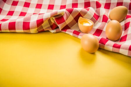Beautiful fresh brown chicken eggs on yellow background with copy space.の写真素材