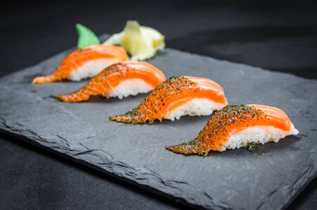Perfect sushi, traditional Japanese cuisine. Delicious salmon kiguiri on the decorated plate, black background.の写真素材