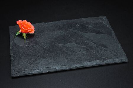Empty slate plate on black background for use in culinary photos.の写真素材