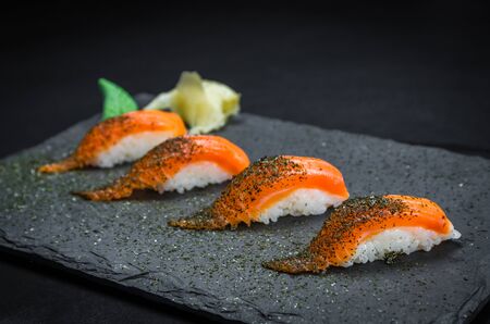 Perfect sushi, traditional Japanese cuisine. Delicious salmon kiguiri on the decorated plate, black background.の写真素材