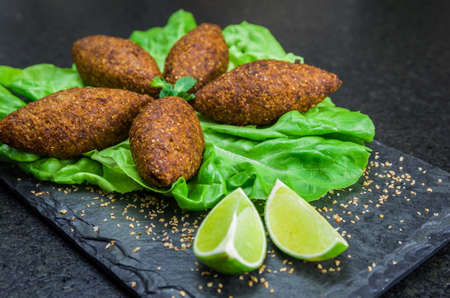 Delicious Lebanese (Arabic) food, kibbeh (kibe) on black slate stone and granite background.の写真素材