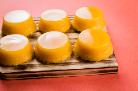 Delicious Quindins on wooden board, traditional Brazilian dessert made with egg yolk, sugar and coconut.の写真素材