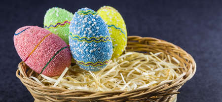 Easter colored eggs in a basket isolated on a trendy black background. Minimal easter concept....