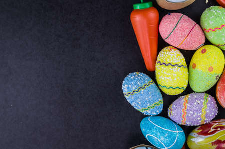 Colorful Easter eggs and other objects on a trendy black background for various Easter themed backgroundsの写真素材