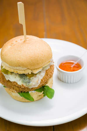 Close-up of homemade tasty chicken burger on wooden table and black background.の写真素材