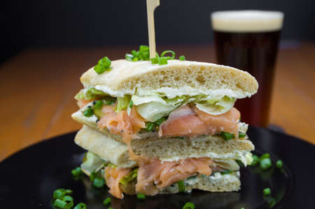 Delicious salmon sandwich close-up and glass of beer.の写真素材