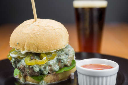 Close-up of tasty homemade hamburger on wooden table and black backgroundの写真素材