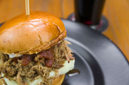 Close-up of tasty homemade pulled pork burger on wooden table and black backgroundの写真素材