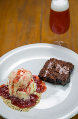 Close-up of delicious chocolade brownie dessert with cream ice cream and raspberry beerの写真素材
