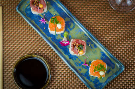 Delicious premium salmon and tuna Oshizushi sushi (Sushi Drum) on a decorated handmade porcelain plate.の写真素材