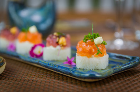 Delicious premium salmon and tuna Oshizushi sushi (Sushi Drum) on a decorated handmade porcelain plate.の写真素材