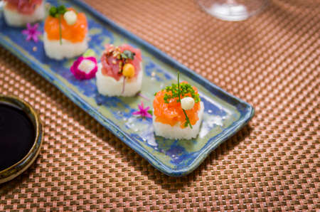 Delicious premium salmon and tuna Oshizushi sushi (Sushi Drum) on a decorated handmade porcelain plate.の写真素材