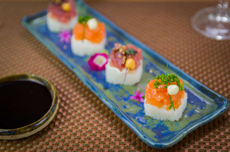 Delicious premium salmon and tuna Oshizushi sushi (Sushi Drum) on a decorated handmade porcelain plate.の写真素材