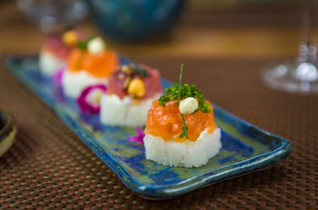 Delicious premium salmon and tuna Oshizushi sushi (Sushi Drum) on a decorated handmade porcelain plate.の写真素材
