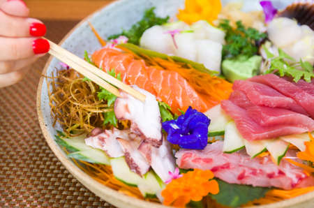 Woman eating delicious sushi, closeup on chopsticksの写真素材