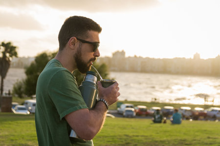 Man drinking chimarrao, mate (an infusion of yerba mate with hot water) at sunset in uruguay