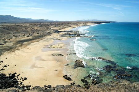 Spain, the Spanish Canary island of Fuerteventura. Atlantic waves crash onto the sandy shore.