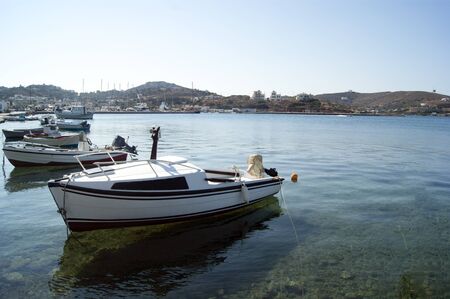 Spain â€“ Lipsi island. Small fishing boats moored in tranquil waters of the harbor, on a...