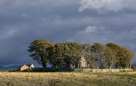 Wales, the north coast at the Irish sea, near Caernarfon. An autumn, early winter scene with brightly sun lit fields and storm clouds.の写真素材