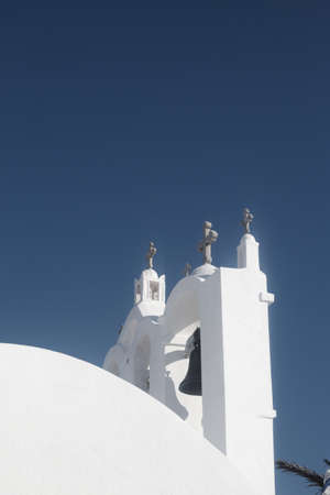Sikinos island, Greece. Beautiful traditional church bell tower. Vertical shot with blue sky background for copy space. Photo taken in the old villageの写真素材