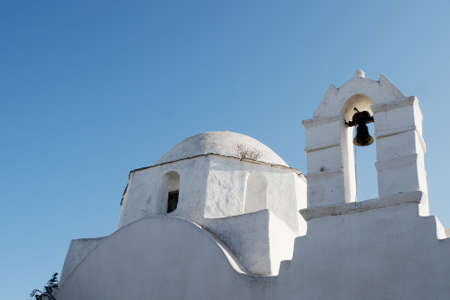 Folegandros island Greece. Beautiful church in the old town. Low angle shot of bell tower and dome. Blue sky background, copy space. Landscape aspectの写真素材