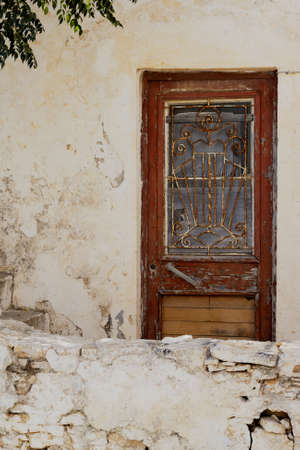 Folegandros island Greece. Village house in the old town. Dilapidated,  but still charming. Front of building. Ornate weathered door. Copy space.の写真素材