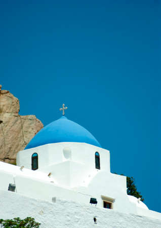 Beautiful traditional chapel on the hillside above the island  old village.の写真素材