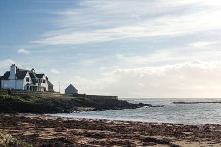 Rhosneigr, Anglesey, Wales. Winter landscape view of low cliffs and a bay with waves breaking on the beach.  Blue sky and copy space.の写真素材