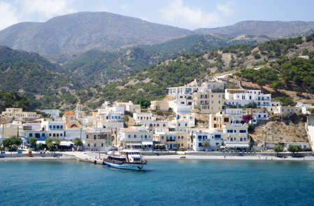 Karpathos - Greece - August 26 2014 : Scenic Diafani port. Beautiful landscape view of the waterfront with a background of pine clad mountainsのeditorial素材