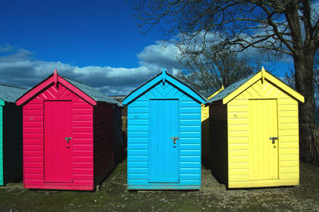 Iconic, old fashioned beach huts. Typical British seaside scene at Abersoch, north Wales on a sunny spring day. Close up viewの写真素材