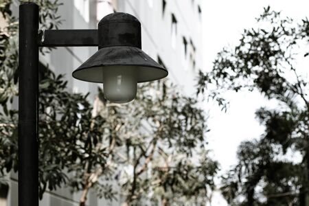 Vintage Black Iron Hanging Street Lamp with Three White Glass Globes beside Balconies