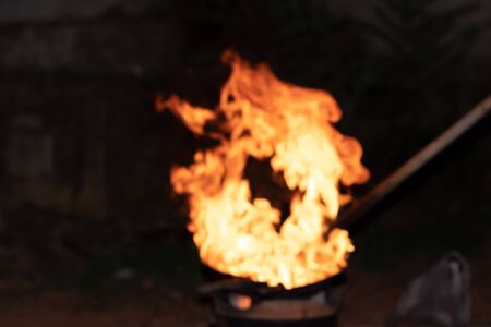 Defocused and blurred image for background. Red orange flame from the fire on the pan roasting...